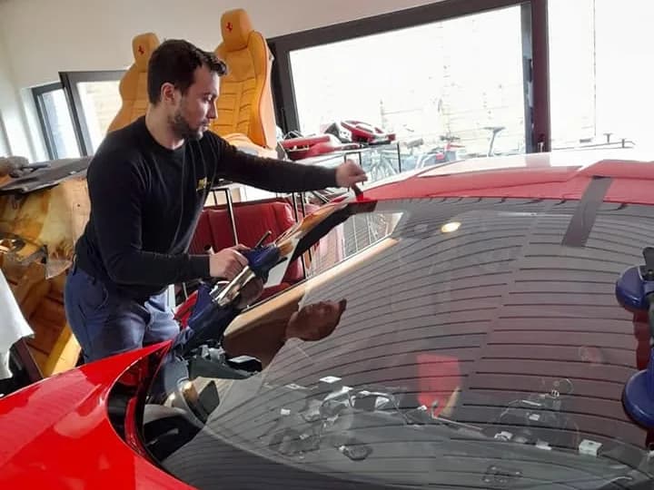 Monteur neemt de voorruit uit de Ferrari, van bovenaf gezien
