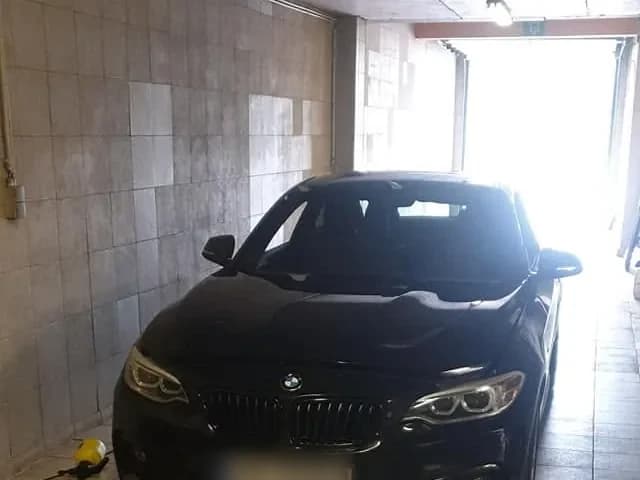 Zwarte BMW 5-serie op de brug in de werkplaats