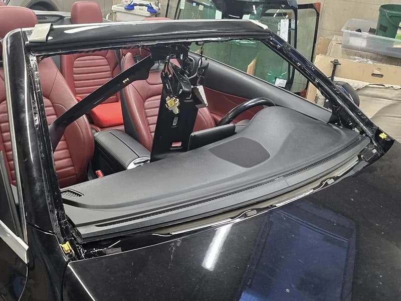 Cabrio met rood interieur waarvan de voorruit is uitgenomen