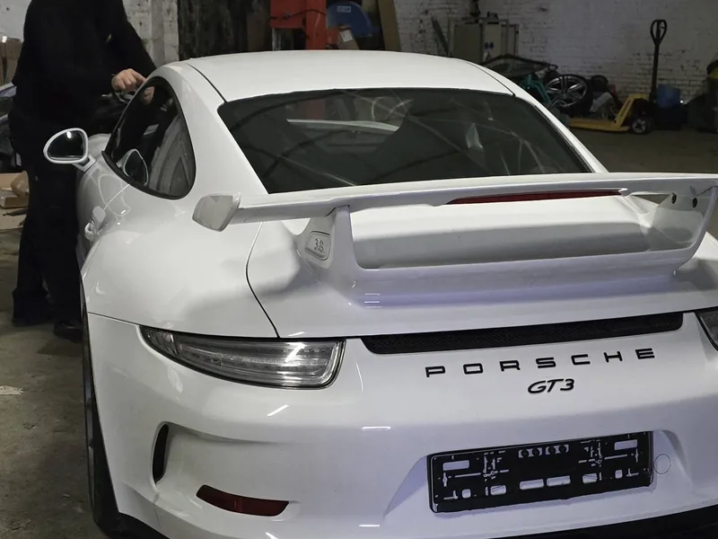 Witte Porsche 911 GT3 van achteren in de werkplaats