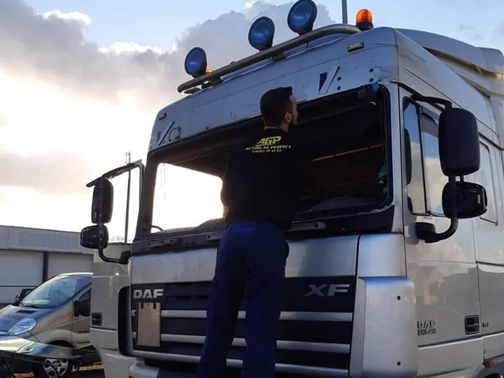 Monteur aan de voorruit van een DAF XF, buiten