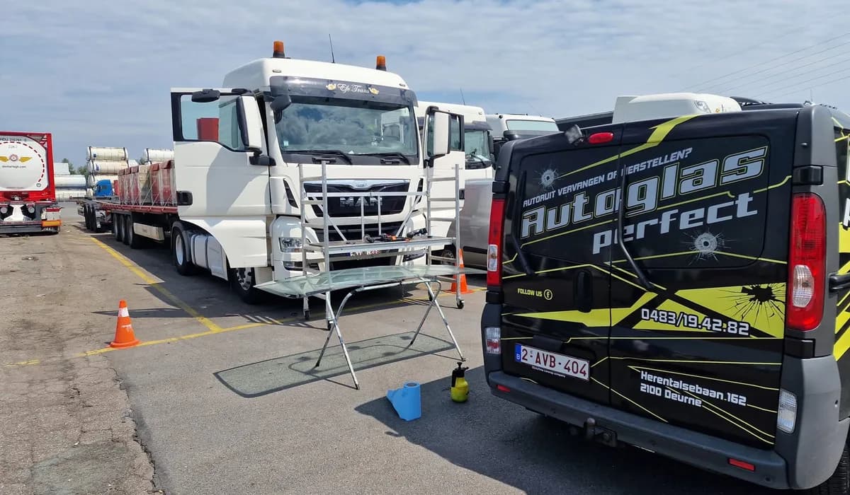Nieuwe vrachtwagenruit op een bok naast een MAN-trekker, met de bestelwagen van Autoglas Perfect ernaast